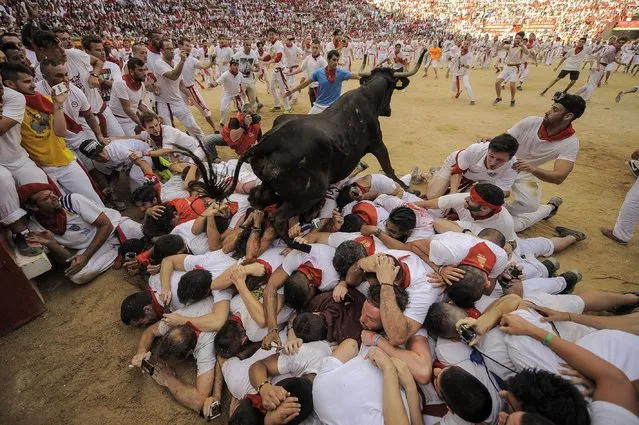 A cow jumps over a group of revelers on the bull ring, at the San Fermin Festival, in Pamplona, Spain, Wednesday, July 8, 2015. (Photo by Alvaro Barrientos/AP Photo)
