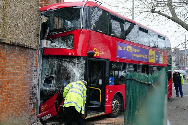 Emergency services at the scene on the Broadway after a bus crashed into a building, in Highams Park, east London, Tuesday, January 25, 2022. (Photo by Victoria Jones/PA Wire via AP Photo)