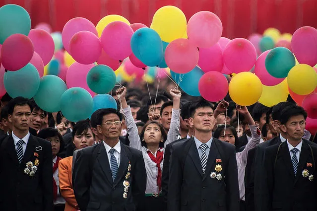 Participants wait to take part in a mass parade marking the end of the 7th Workers Party Congress in Kim Il-Sung square in Pyongyang on May 10, 2016. North Korea kicked off a massive parade in the centre of Pyongyang on May 10 to celebrate a just-concluded ruling party congress that was seen as a formal coronation for supreme leader Kim Jong-Un. (Photo by Ed Jones/AFP Photo)