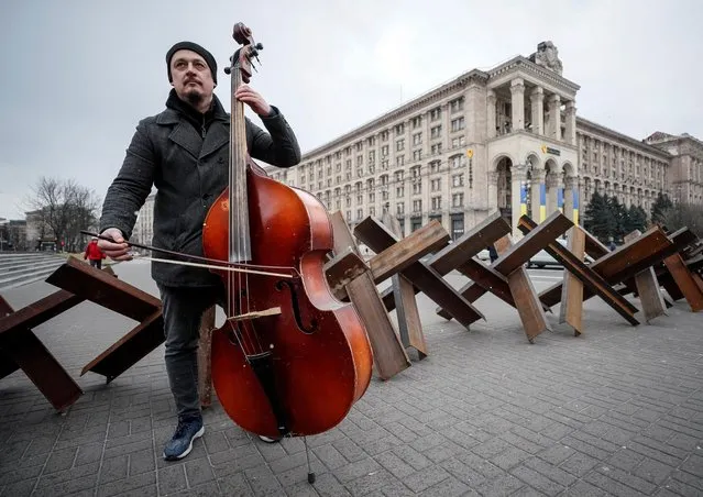 Oleksey Beregoviy, a musician of the Kyiv-Classic Symphony Orchestra, performs for journalists and people after an open-air concert named “Free Sky” at the Independence Square in central Kyiv, Ukraine March 9, 2022. (Photo by Gleb Garanich/Reuters)