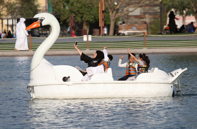 A woman takes a selfie with her children as they ride a boat at Aspire Park in Doha, Qatar April 8, 2016. (Photo by Naseem Zeitoon/Reuters)