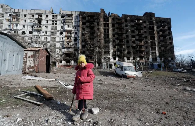 A girl walks in the courtyard of an apartment building destroyed in the course of Ukraine-Russia conflict in the besieged southern port city of Mariupol, Ukraine on March 28, 2022. (Photo by Alexander Ermochenko/Reuters)