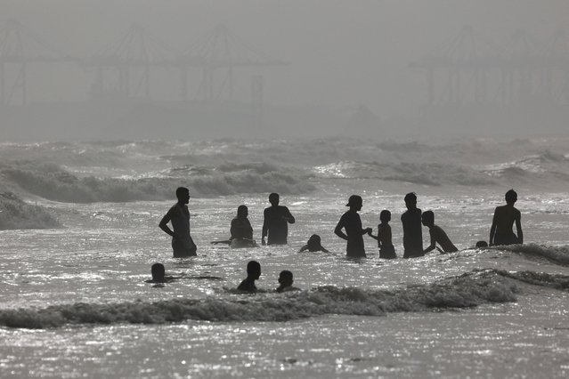 People are silhouetted as they take a bath in the Arabian Sea near Clifton Beach during a hot and humid day in Karachi, Pakistan on June 1, 2024. (Photo by Akhtar Soomro/Reuters)