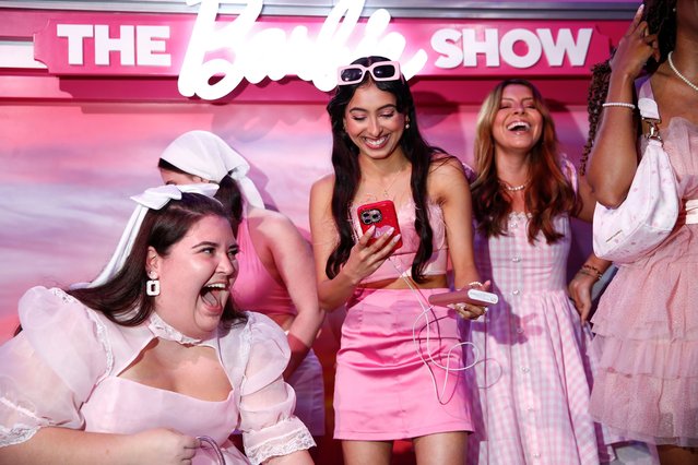 A group of people laugh together after filming a video during the World of Barbie immersive experience preview in Santa Monica, California, USA on April 12, 2023. (Photo by Caroline Brehman/EPA/EFE)