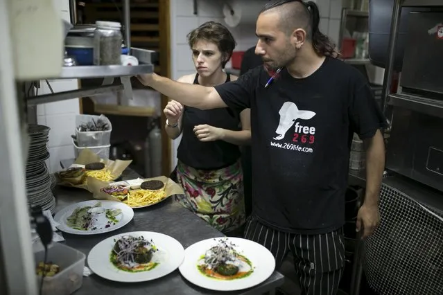 A cook wearing a T-shirt of an animal rights movement works in the kitchen of Georgian restaurant Nanuchka in Tel Aviv, Israel July 15, 2015. (Photo by Baz Ratner/Reuters)