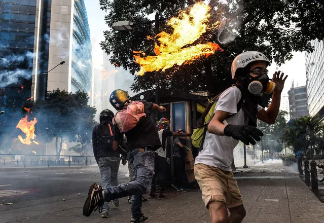 Demonstrators clash with riot police during a protest against the government of President Nicolas Maduro in Caracas on May 20, 2017. Venezuelan protesters and supporters of embattled President Nicolas Maduro take to the streets Saturday as a deadly political crisis plays out in a divided country on the verge of paralysis. (Photo by Federico Parra/AFP Photo)