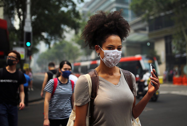 Pedestrians wear masks as smoke and haze from bushfires in New South Wales blankets the CBD in Sydney, Australia, 10 December 2019. The New South Wales environment department says visibility across east and southwest Sydney was at a “hazardous” level on Tuesday morning, while air quality was poor in southwest Sydney and hazardous in northwest Sydney. (Photo by Steven Saphore/EPA/EFE)