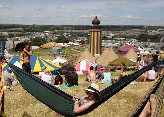 A woman relaxes in a hammock during the hot weather at the Glastonbury Festival, at Worthy Farm in Somerset. (Photo by Yui Mok/PA Wire)