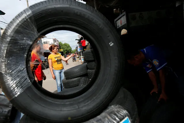 A Venezuelan woman looks for tires at a stall in Puerto Santander, Colombia, June 3, 2016. (Photo by Carlos Garcia Rawlins/Reuters)