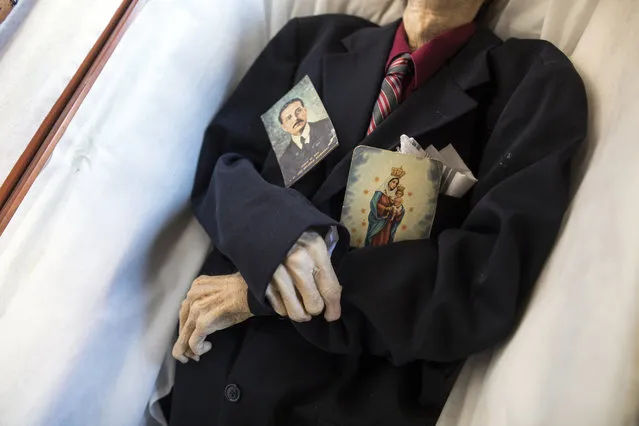 A man's body lies in a coffin before being cremated at a cemetery Maracaibo, Venezuela, November 23, 2019. The man's family said they cremated him because it is much cheaper than burial, and took his ashes home. (Photo by Rodrigo Abd/AP Photo)