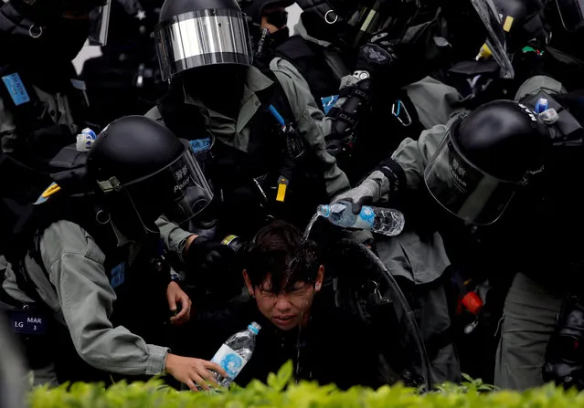 Riot police pour water on the face of an anti-government protester who was pepper sprayed while getting detained after an anti-parallel trading protest at Sheung Shui, a border town in Hong Kong, China, January 5, 2020. (Photo by Navesh Chitrakar/Reuters)