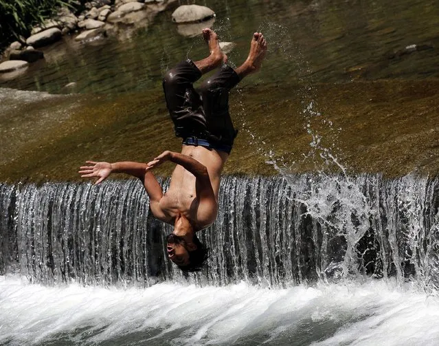 A Kashmiri man jumps from a waterfall to beat the heat on a hot day on the outskirts of Srinagar, the summer capital of Indian Kashmir, 14 June 2016. The weather is getting hotter in Indian Kashmir while Muslims are fasting from dawn to dusk during the Muslim holy fasting month of Ramadan. (Photo by Farooq Khan/EPA)