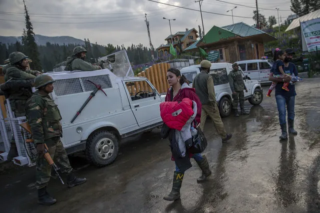 Indian tourists walk back after they were rescued from a cable car in Gulmarg, northwest of Srinagar, Indian controlled Kashmir, Sunday, June 25, 2017. Four Indian tourists and three local residents died on Sunday when a cable car came crashing down from a height of at least 30 meters (100 feet) in the tourist resort of Gulmarg in the Indian portion of Kashmir. Authorities restored the cable and rescued nearly 100 people stranded in cable cars on the ropeway. (Photo by Dar Yasin/AP Photo)