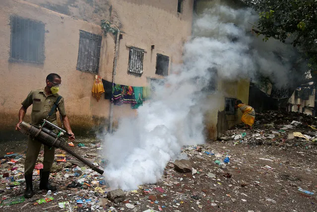 A municipal worker fumigates a slum area to prevent the spread of dengue fever and other mosquito-borne diseases in Mumbai, India, July 19, 2017. (Photo by Shailesh Andrade/Reuters)