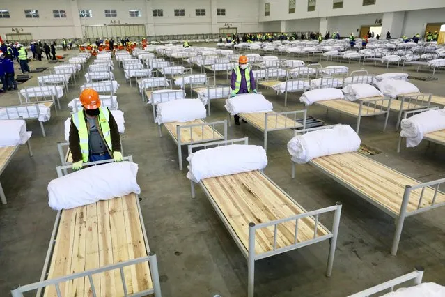 Workers set up beds at the Wuhan Parlor Convention Center to convert it into a makeshift hospital following an outbreak of the new coronavirus, in Wuhan, Hubei province, China, February 4, 2020. (Photo by Reuters/China Daily)