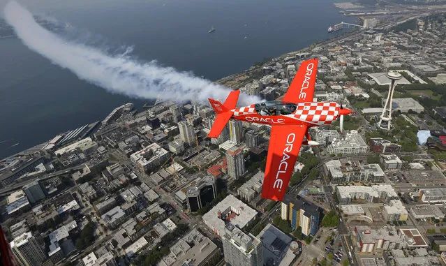 Team Oracle stunt pilot Sean D. Tucker flies his Extra 300L plane above the Space Needle, Wednesday, August 2, 2017, in Seattle. In the rear seat is Seattle Seahawks tight end Jimmy Graham, who is also a stunt pilot and was invited along by Tucker as Tucker prepared for his performances at the Seafair Air Show Saturday and Sunday, Aug. 5-6, 2017. (Photo by Ted S. Warren/AP Photo)