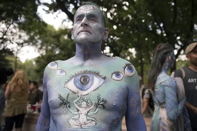 Jack van Riper, of New Jersey, stands for a photograph after being painted at Columbus Circle as body-painting artists gathered to decorate nude models as part of an event featuring artist Andy Golub, Saturday, July 26, 2014, in New York. Golub says New York was the only city in the country that would allow his inaugural Bodypainting Day. (Photo by John Minchillo/AP Photo)