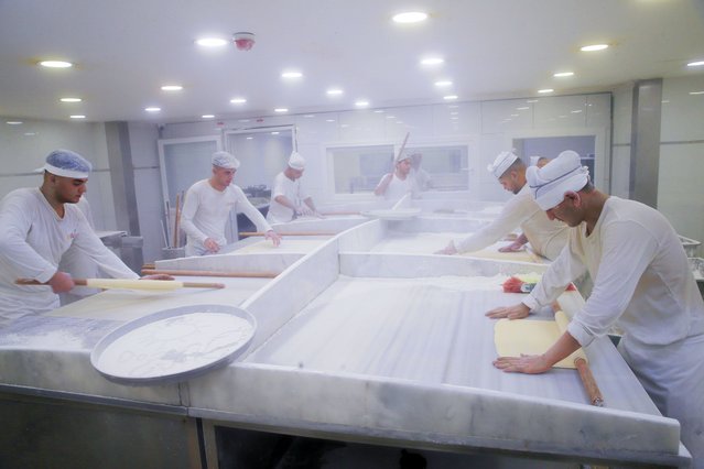 Bakers roll dough in a baklava bakery ahead of the Eid Al-Adha in Istanbul, Turkiye on July 07, 2022. (Photo by Yasin Aras/Anadolu Agency via Getty Images)