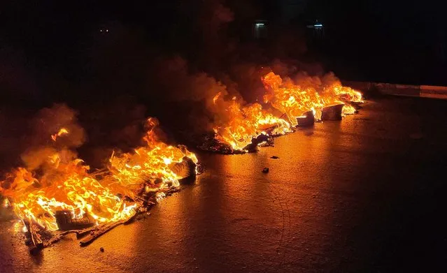 A picture taken on June 3, 2022, shows burning tyres blocking roads during overnight protests in the Libyan capital Tripoli. Libya's rival leaders were under growing street pressure Saturday after protesters stormed parliament as anger exploded over deteriorating living conditions and political deadlock. (Photo by Mahmud Turkia/AFP Photo)