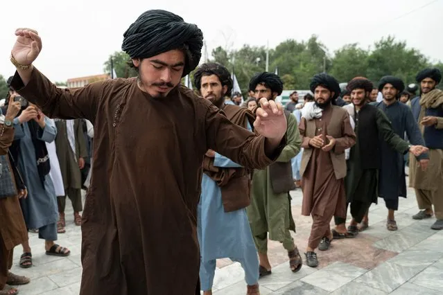 Taliban fighters dance as they celebrate their victory at the Ahmad Shah Massoud Square in Kabul on August 15, 2022. (Photo by Wakil Kohsar/AFP Photo)
