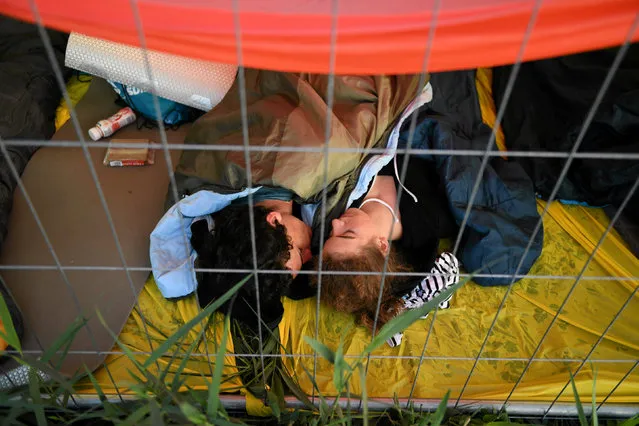 Pilgrims rest behind a fence at the Campus Misericordiae during World Youth Day in Brzegi near Krakow, Poland, July 31, 2016. (Photo by Lukasz Krajewski/Reuters/Agencja Gazeta)