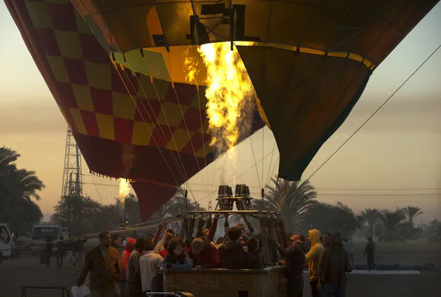 In this April 1, 2016 file photo, a hot air balloon prepares to take off on the west bank of the Nile River in Luxor, Egypt. They take off at first light, providing sky-high views of antiquities below. Luxor in southern Egypt is one of the world's largest outdoor museums, with majestic temples and tombs of ancient kings. The weekend’s hot balloon crash in Texas has been a grim reminder of a similar but deadlier accident in Egypt three years ago, when 18 foreign tourists burnt to death before plummeting to earth as their sightseeing sunrise flight over the famed temples of the ancient city of Luxor drew to a close. (Photo by Amr Nabil/AP Photo)