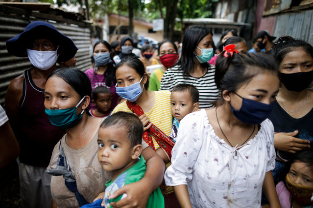 People wear masks as they queue for free lunch amid the coronavirus outbreak at a slum area in Jakarta, Indonesia, 22 April 2020. Countries around the world are taking increased measures to stem the widespread of the SARS-CoV-2 coronavirus which causes the COVID-19 disease. (Photo by Mast Irham/EPA/EFE)