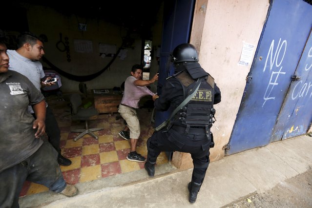 A riot police officer tries to detain a man during a protest against the re-election of the city's mayor Rubelio Recinos of the Patriot Party in Barberena, northwest of Guatemala City, September 8, 2015. (Photo by Jorge Dan Lopez/Reuters)