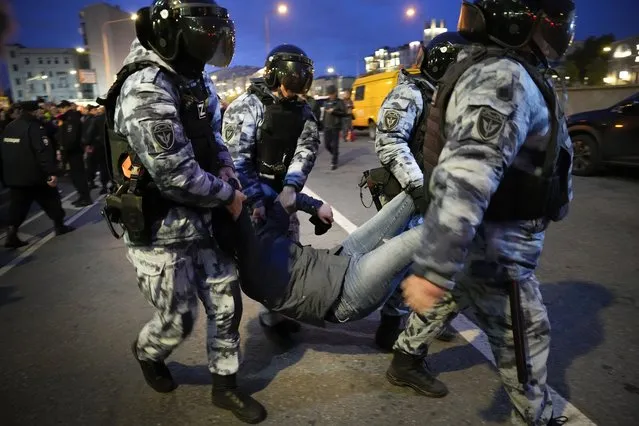 Riot police detain a demonstrator during a protest against mobilization in Moscow, Russia, Wednesday, September 21, 2022. (Photo by Alexander Zemlianichenko/AP Photo)
