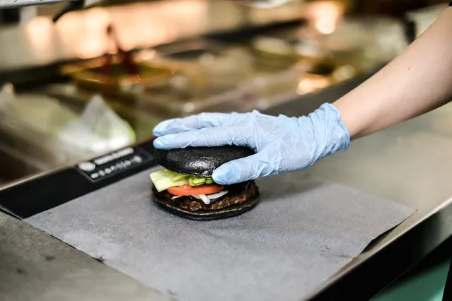 A Burger King employee prepares a black burger at a company restaurant on September 18, 2014 in Tokyo, Japan. (Photo by Keith Tsuji/Getty Images)