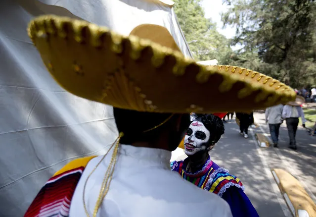 Revelers wait for the start of a Day of the Dead parade to begin along Mexico City's main Reforma Avenue, Saturday, October 28, 2017. (Photo by Eduardo Verdugo/AP Photo)