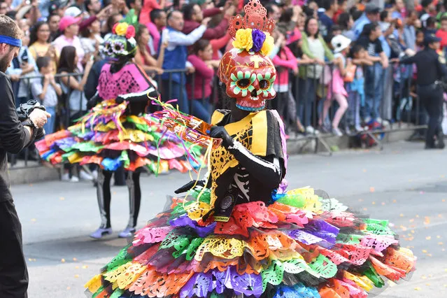 People are seen participate during the traditional Skulls Parade as part of Day of the Dead celebrations at Reforma Avenue on October 28, 2017 in Mexico City, Mexico. (Photo by Carlos Tischler/NurPhoto via Getty Images)