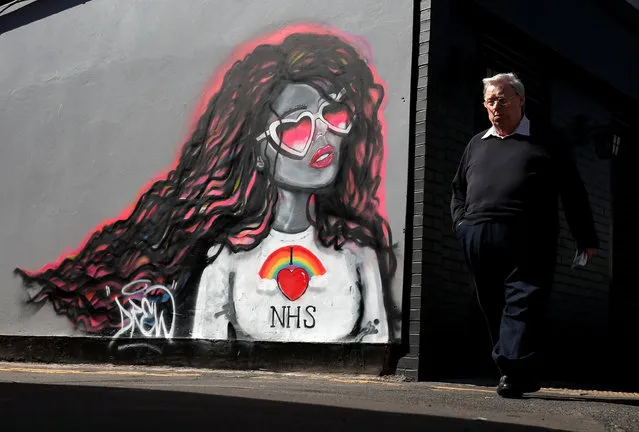 A man passes by a mural in support of the NHS, as the spread of the coronavirus disease (COVID-19) continues, in Redcar, Britain, April 24, 2020. (Photo by Lee Smith/Reuters)