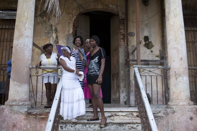 People talk during the party of Yensy Villarreal, 9, (not pictured), in celebration for becoming a Santero after passing a year-long rite of passage in the Afro-Cuban religion Santeria, Havana, July 5, 2015. (Photo by Alexandre Meneghini/Reuters)