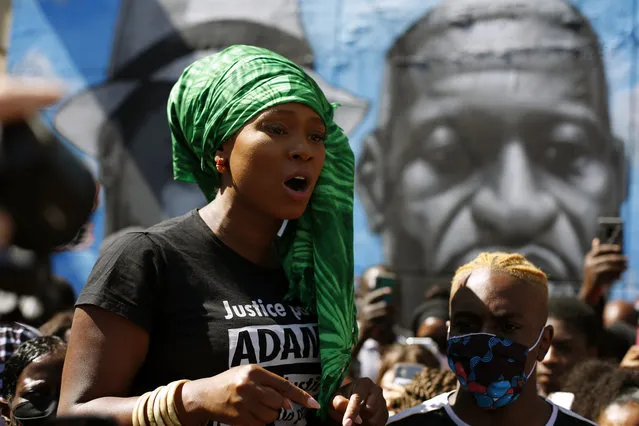 Assa Traore delivers a speech in front of a mural showing her brother Adama Traore, with George Floyd, in Stains, north of Paris, Monday, June 22, 2020. French police officers gathered in Bobigny, in the Paris suburbs, on call from police union Alliance. They called for a mural painting in homage to a French Black man who died in police custody, writing “against racism and police brutality”, to be removed. Adama Traore died in 2016 in circumstances that remain unclear despite four years of back-and-forth autopsies. (Photo by Thibault Camus/AP Photo)