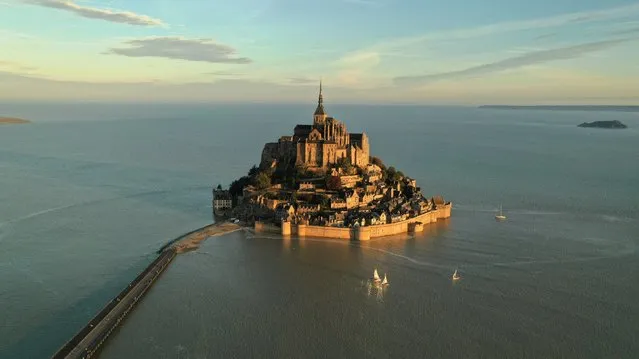 An aerial view shows the iconic Mont-Saint-Michel surrounded by sea at sunrise, during the highest tide of the year, in France's Normandy coast, September 11, 2022. (Photo by Pascal Rossignol/Reuters)