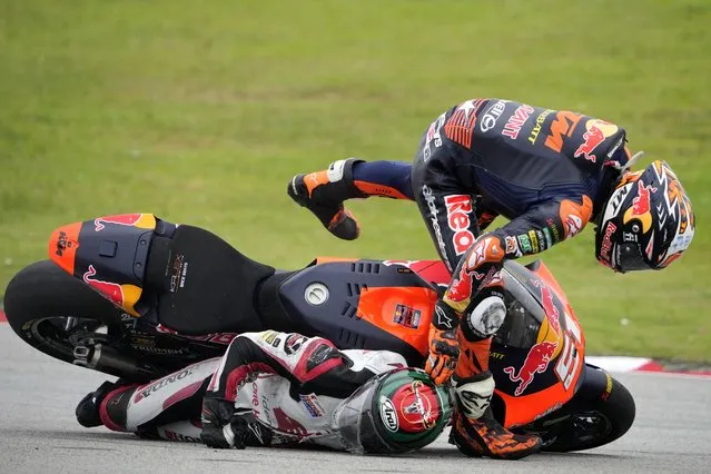 Spain's Pedro Acosta of Red Bull KTM Ajo, top, crashes with Thailand's Somkiat Chantra of Idemitsu Honda Team Asia during the Moto2 race for the Malaysia Motorcycle Grand Prix in Sepang International Circuit, Sunday, October 23, 2022. (Photo by Vincent Thian/AP Photo)