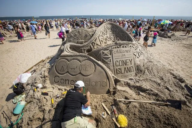 A man works on his creation during the Coney Island Sand Sculpting Contest at Coney Island in Brooklyn, New York August 15, 2015. (Photo by Andrew Kelly/Reuters)