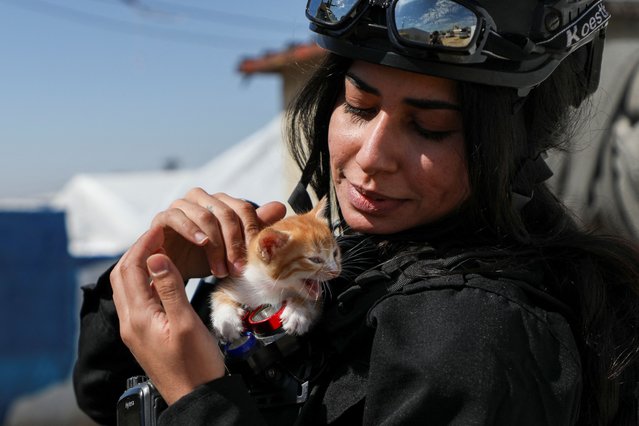 A member of Kurdish internal security forces holds a cat as Women's Protection Unit (YPJ) and Kurdish internal security forces conduct a security operation in al-Roj camp, Syria, on April 6, 2025. (Photo by Orhan Qereman/Reuters)