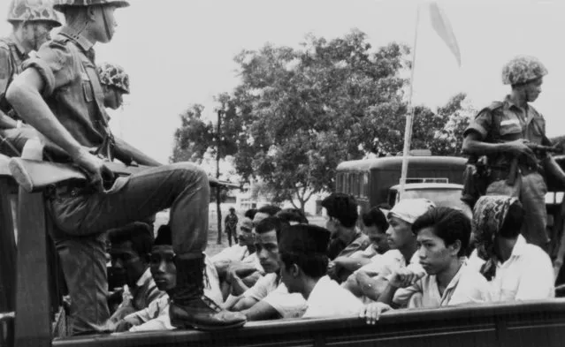 In this October 30, 1965, file photo, members of the Youth Wing of the Indonesian Communist Party (Pemuda Rakjat) are watched by soldiers as they are taken to prison in Jakarta following a crackdown on communists after an abortive coup against President Sukarno's government earlier in the month. Declassified files have revealed new details of American government knowledge and support of an Indonesian army extermination campaign that killed several hundred thousand civilians during anti-communist hysteria in the mid-1960s. (Photo by AP Photo)