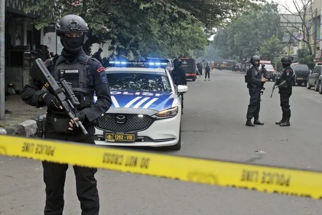 Police officers secure a road leading to a police station where a bomb exploded in Bandung, West Java, Indonesia, Wednesday, December 7, 2022. A man blew himself up Wednesday at a police station on Indonesia's main island of Java in what appeared to be the latest in a string of suicide attacks in the world's most populous Muslim nation. (Photo by Kholid Parmawinata/AP Photo)