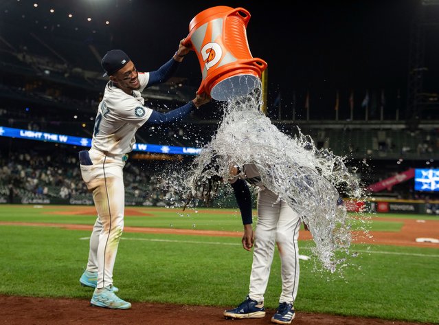 Seattle Mariners' Julio Rodriguez douses J.P. Crawford with wather after a baseball game against the New York Yankees, Tuesday, May 13, 2025, in Seattle. (Photo by Stephen Brashear/AP Photo)