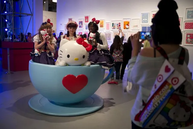 Hello Kitty fans pose for photos in a giant tea cup at the Hello Kitty Con, the first-ever Hello Kitty fan convention, held at the Geffen Contemporary at MOCA Thursday, October 30, 2014, in Los Angeles. (Photo by Jae C. Hong/AP Photo)