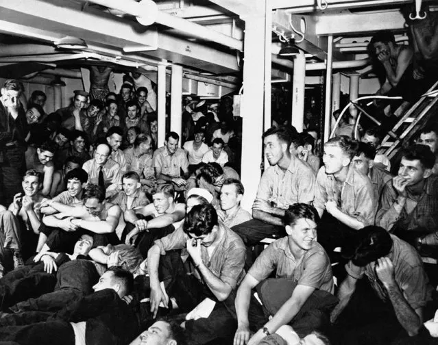 A crew of a U.S. cruiser gather below decks on December 28, 1944 while at sea to witness an exhibition of motion pictures distributed by the U.S. Navy Motion Picture Exchange. (Photo by AP Photo)