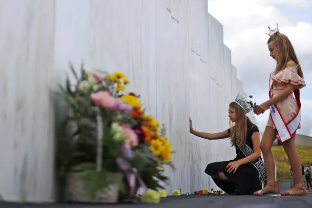 Mackenzie, right, and Madison Miller from Avonmore, Pa., visit the Wall of Names at the Flight 93 National Memorial in Shanksville, Pa., Thursday, September 10, 2020, as the nation prepares to mark the 19th anniversary of the Sept. 11, 2001, attacks. The Wall of Names honors the 40 people killed in the crash of Flight 93. (Photo by Gene J. Puskar/AP Photo)