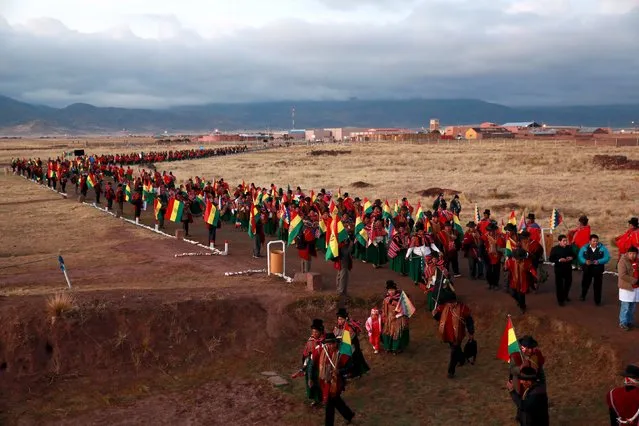 People attend a ceremony celebrating Bolivian President Evo Morales' record tenure in office, at the Tiahuanaco ruins, north of La Paz, October 21, 2015. Morales celebrated on Wednesday his record tenure as Bolivia's president, in power for nine years, eight months and 27 days, according to local media. (Photo by Reuters/Bolivian Presidency)