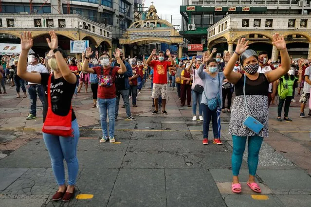 Filipino devotees attend mass while maintaining social distancing outside the Minor Basilica of the Black Nazarene, amid the coronavirus disease (COVID-19) outbreak, in Quiapo, Manila, Philippines, October 2, 2020. (Photo by Eloisa Lopez/Reuters)