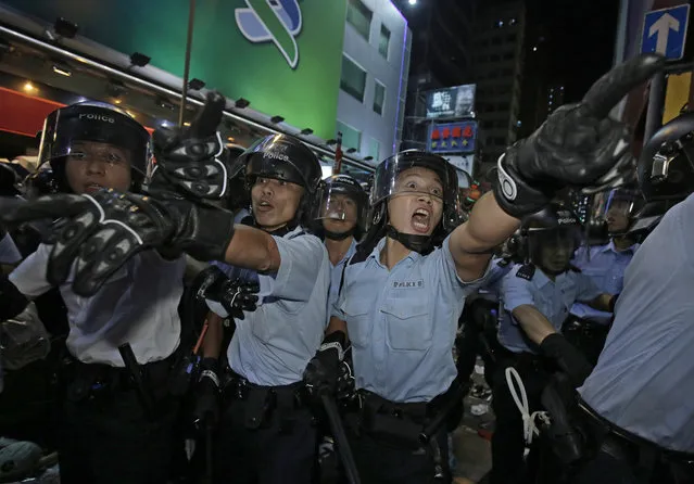 Police officers shout at protesters at an occupied area in Mong Kok district of Hong Kong Tuesday, November 25, 2014. An attempt by Hong Kong authorities to clear a 2-month-old pro-democracy protest camp in Mong Kok district spiraled into chaos Tuesday as hundreds more protesters flooded the crowded neighborhood, a flashpoint for earlier violent clashes with police and angry mobs. A total of 80 people were arrested, police said. (Photo by Vincent Yu/AP Photo)
