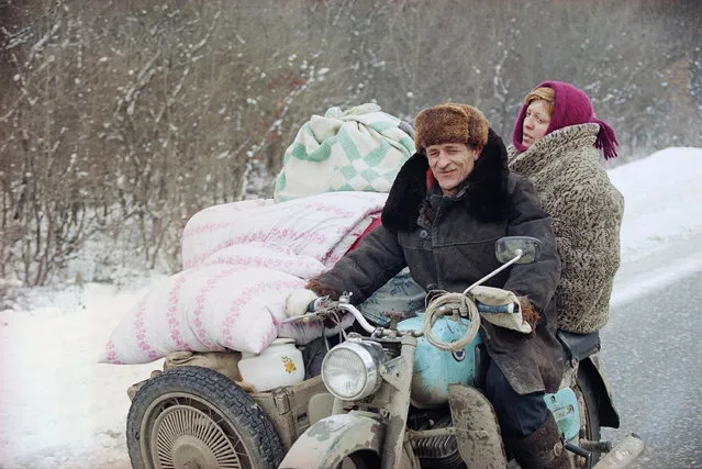 A Chechen refugee couple leaves Grozny with their belongings packed in the sidecar of their motorbike, January 26, 1995, as Russian forces continue to advance on the Chechen capital. (Photo by Karsten Thielker/AP Photo/File)