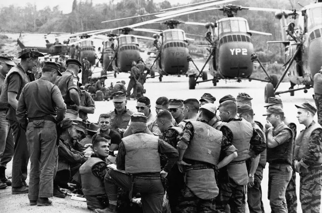 United Sates Marines Helicopter Squadron huddled at Da Nang in 1963 for the final briefing on a March 31, 1965, mission: to airlift a battalion of Vietnamese infantry to an isolated area about 20 miles away. (Photo by Larry Burrows/Time & Life Pictures)